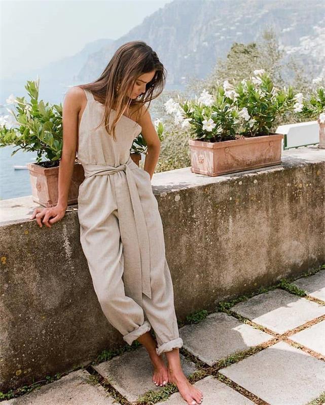 Šviesiai smėlio spalvos stilingas kombinezonas su ilgomis lininėmis kelnėmis, atsitiktinė prašmatni moteris, moderni prašmatni apranga, 2019 m. Vasaros tendencijos, nuotrauka Italijoje, graži gamta