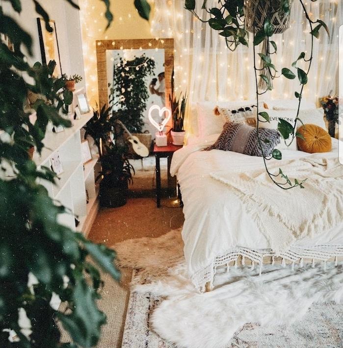 boemski model spalnice z duhom džungle z visečimi rastlinami in lončnicami, posteljnino in belo preprogo, lahkimi venci za romantično vzdušje