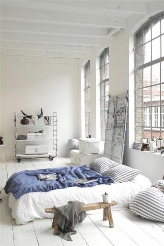 bela posteljnina-temno-modra-posteljna-odeja-bela-tla-bele stene