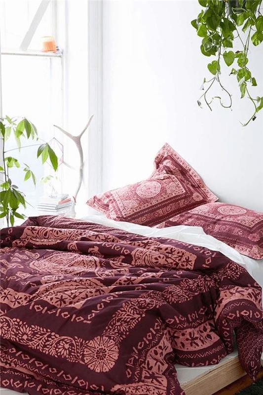 ideja za belo spalnico s posteljnino, prevlekami za vzglavnike in odejo v bordo barvi, zelenimi rastlinami, barvno shemo