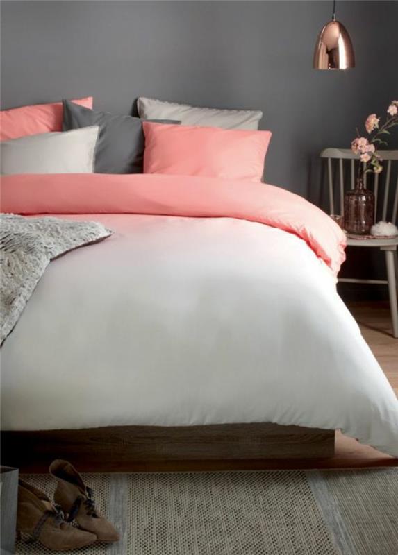 roza in siva spalnica, roza in sive blazine, bela in senčena rožnata posteljna garnitura, lesen stol kot nočna omarica, bakrena viseča svetilka