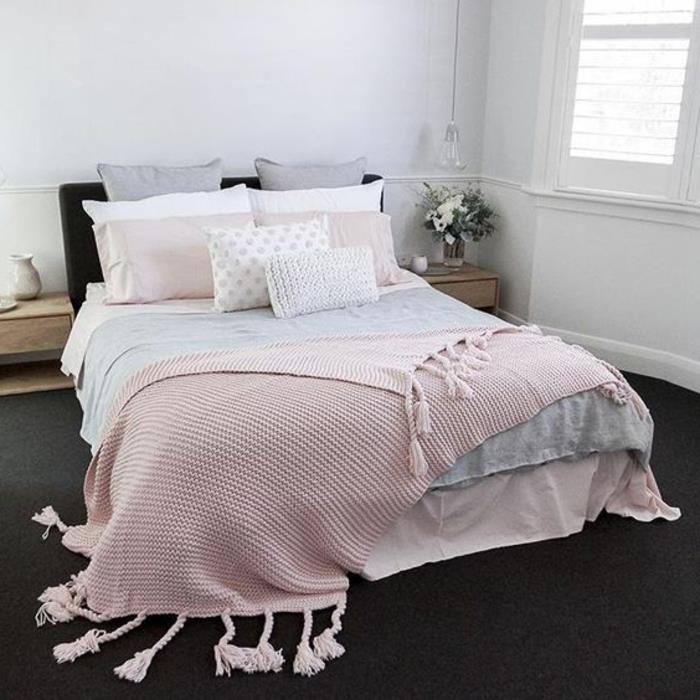 roza, sivo -bela posteljna garnitura, ogljeno siva preproga, bela barva sten, lesene nočne omarice, roza in siva spalnica