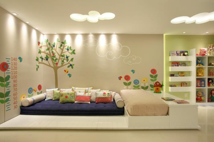 montessori yataklı montessori odası, büyük beyaz platform üzerinde kabin yatağı, reseda tavan, aydınlatan tavan ışıkları ile büyük bulutlar şeklinde açıklıklar