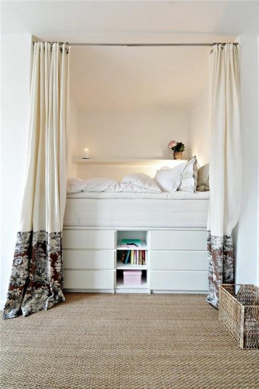 postelja-s-predalom-predal iz ratana-preproga-bež-bele-stene-ratana-preproga-spalnica