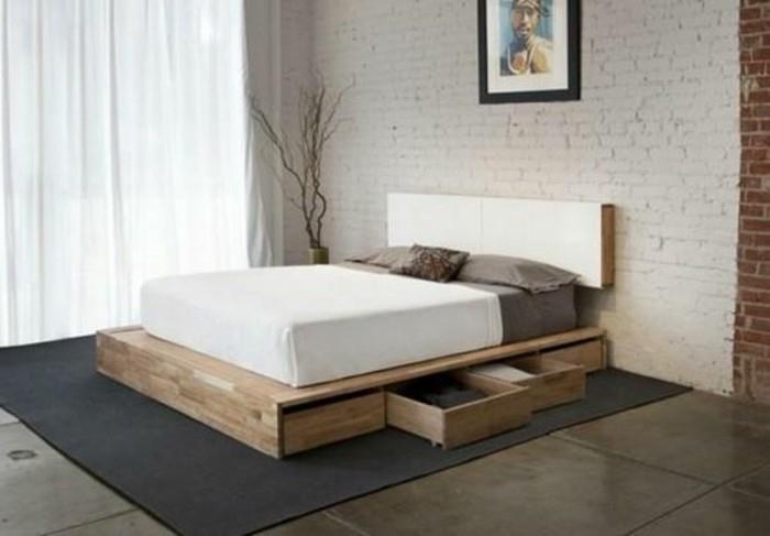 postelja-s-predalom-črna-preproga-spalnica-s-sivimi ploščicami-bela-opečna stena