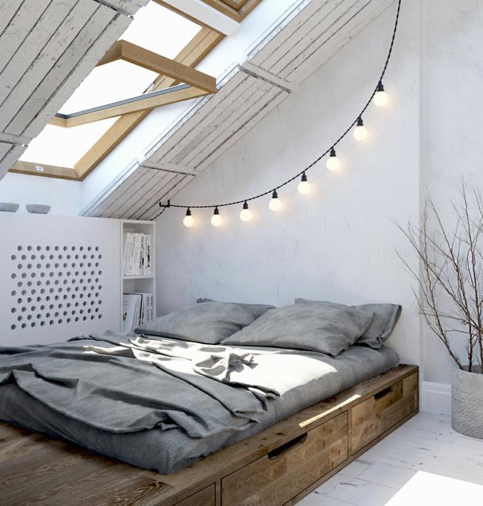 alçak ahşap yatak, beyaz boyalı tahta zemin, ampullerden çelenk, eğimli pencere, modern yetişkin yatak odası dekoru