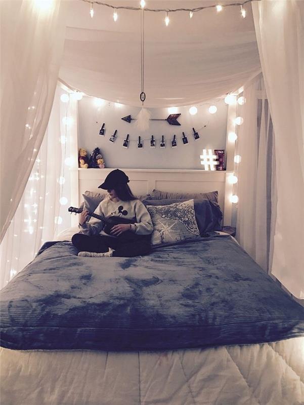 Kakšen dekor najstniške spalnice izbrati, spalnica tumblr z veliko svetlobnimi venci, dekle, ki igra kitaro, sedi na svoji prijetni postelji
