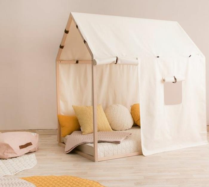 medinė kajutė, burės, geltonos ir baltos spalvos pagalvėlės, šviesus parketas, kilimas, šviesiai rožinė sienų spalva, Montessori metodo vaikų miegamojo baldai