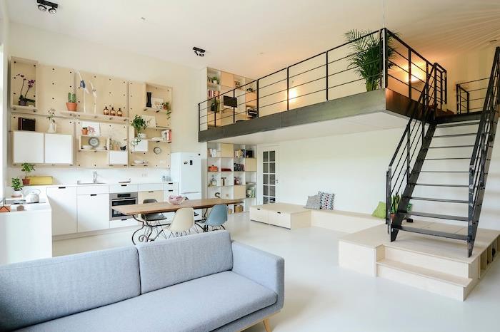 Ideja za postavitev majhnega stanovanja z belo kotno kuhinjo, kuhinjsko omarico, belim podom in sivim kavčem
