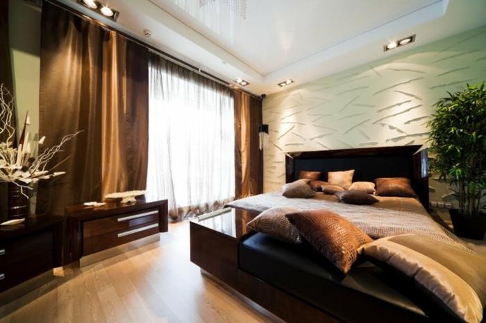 sodobna spalnica z wenge posteljo, več okrasnimi blazinami, rjavimi zavesami, osvetljenim stropom