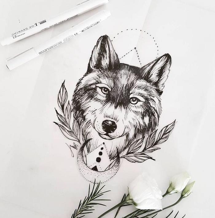 preprosta črno -bela risba volčje glave, obdane z listjem in polmesecem, ideja oblikovanja tetovaže