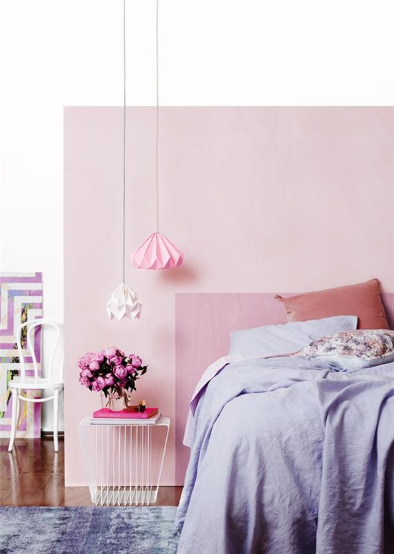 rožinių ir baltų atspalvių sienų tapyba, didelė lova moters kambaryje su kavos staliuku ir origami lemputėmis