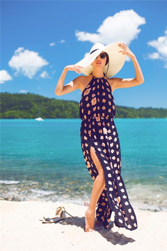 moters ilgos vasaros suknelės ir tamsiai mėlynos spalvos su rožinėmis gėlėmis modelis, paplūdimio aksesuarai su kapelina ir akiniai nuo saulės