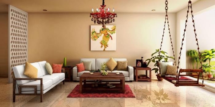 elegantiško etninio stiliaus interjeras smėlio spalvos gyvenamajame kambaryje, apstatytame sofomis ir egzotiškomis sūpynėmis, padengtomis pagalvėmis