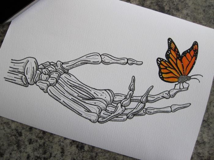 Skeleto ranka ir drugelis ant piršto, kaip nupiešti drugelį, gražaus rašto drugelio spalvinimo idėja