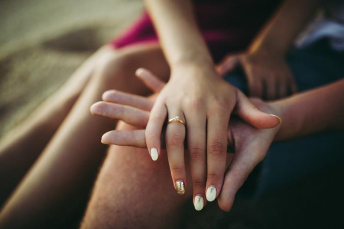 Erkek ve kadının elleri, nişan yüzüğü, sevgililer günü kartı, aşk kartı seçen aşık çiftin görüntüsü