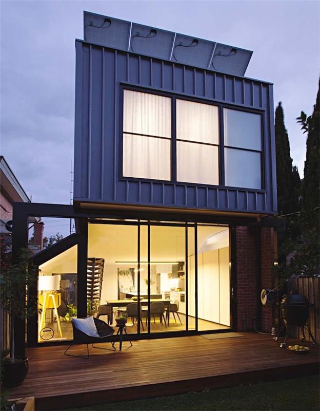modernios architektūros namo priestatas su stikliniais stogais išorinėje medinėje terasoje