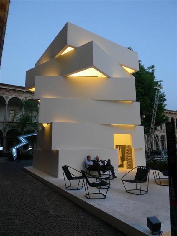 šiuolaikinis minimalistinio stiliaus namas su išoriniais baldais priešais namą