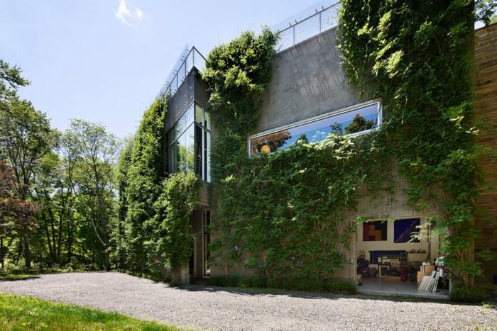 Palette yeşil duvarlı dikey ekim, yerleşim alanı, fütüristik mimariye sahip ev, cam ve metal korkuluklu çatı terası