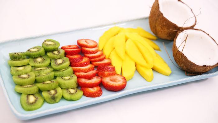 jejte mango v sadni solati, ki jo sestavljajo kivi, jagode, kokos in mango
