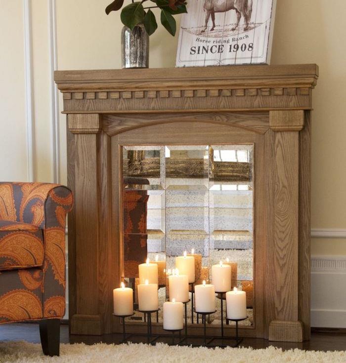 medžio imitacijos spintelė su netikru veidrodžio įdėklu ir žvakėmis svetainės sienoms dekoruoti su kilimu ir oranžine ruda sofa
