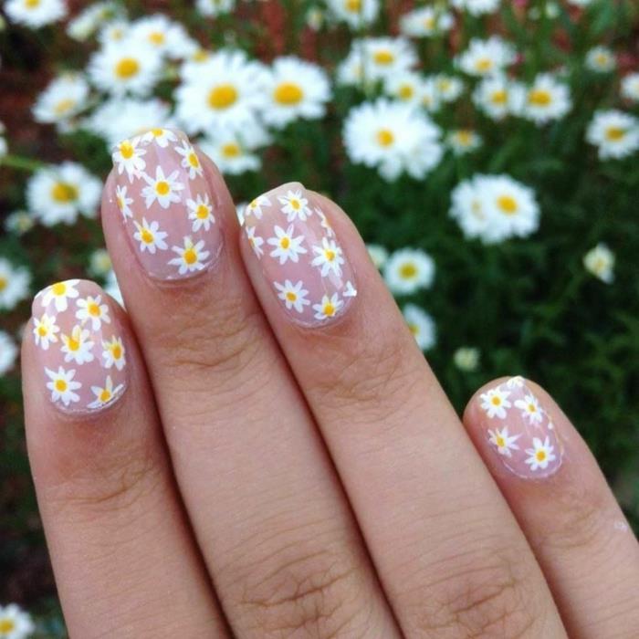 nail art marjetice, ženska manikura s cvetjem v rdeči in beli barvi na svetlo roza ozadju