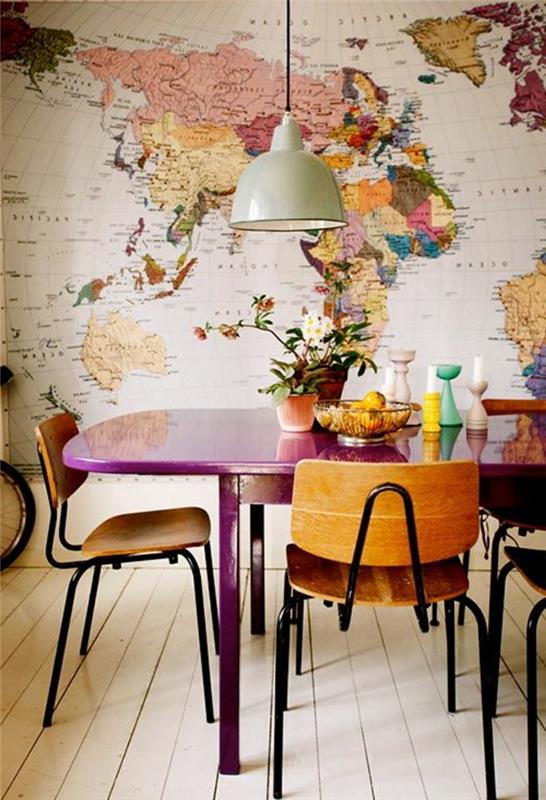 ozadje zemljevida sveta, vijolična lesena miza, dekor na srednji mizi, leseni stoli, lončeno cvetje, svečniki