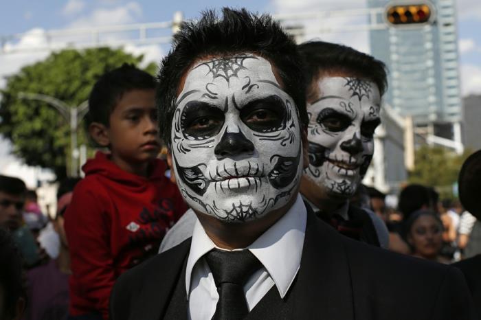 meksika ölüler karnavalına katılanlar, bir adamın yüzüne çizilmiş kafatası kafası, siyah kravat