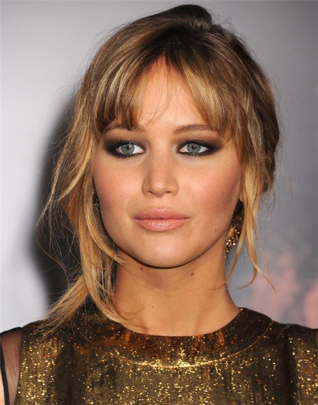 dūminis makiažas, šviesūs plaukai, auksinė suknelė trumpomis rankovėmis, rožinės lūpos, auskarai, Jennifer Lawrence