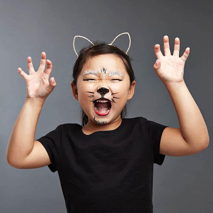 Helovino makiažo mergina kaip katė su diadema dažytomis ausimis ir ūsais