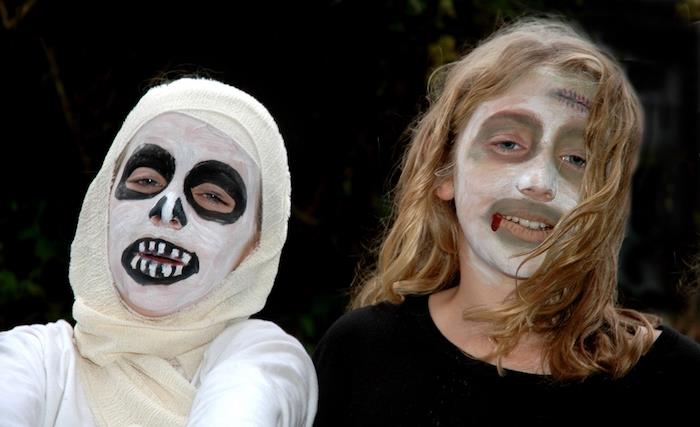 paprastas baisus Halovino makiažas du vaikai, užmaskuoti kaip mumijos balti veido dažai