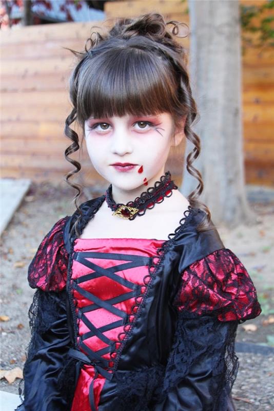 Helovino kostiumo idėja mergaitei vampyrei, vampyrų apranga suknele su mergaitei surištais šukuosenos plaukais