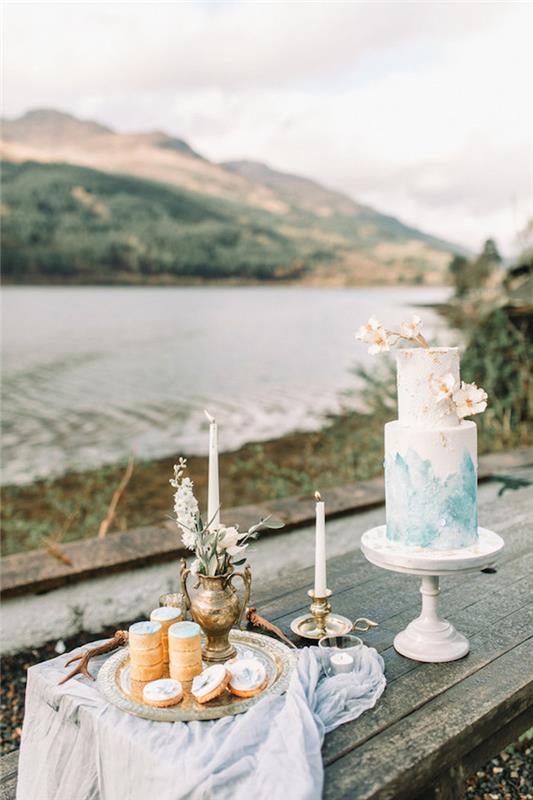 Šokoladinis vestuvinis tortas iš balto cukraus pastos, nudažytas mėlyna spalva prie pagrindo, vestuvinis tortas, originali vaisių ir gėlių vestuvinio torto idėja