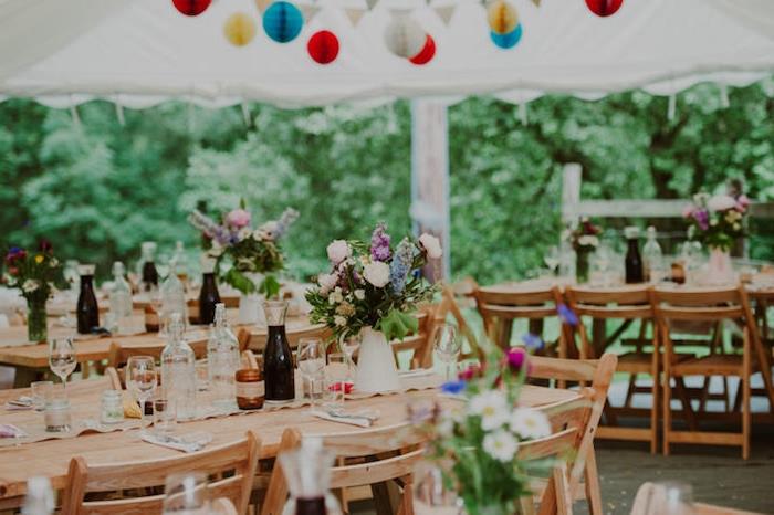 medinis stalas ir kėdės, kaimiškas vestuvių dekoras, ąsotėliai su gėlių puokštėmis, origami spalvingi rutuliukai