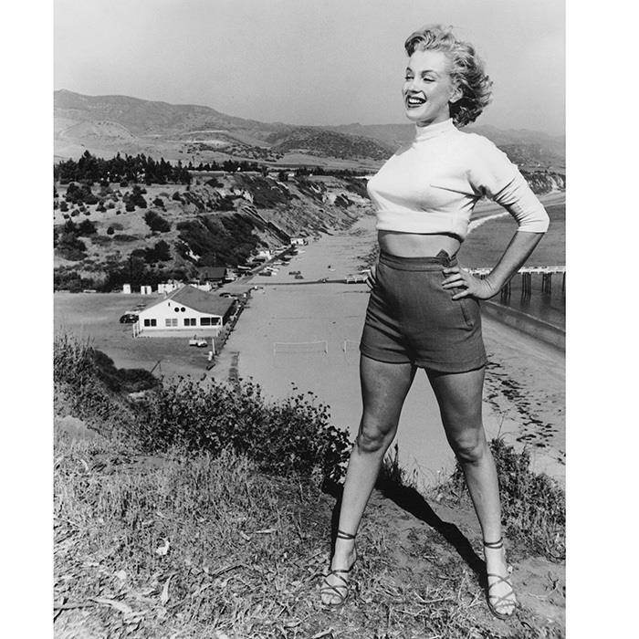 Marilyn Monroe nuotrauka Malibu paplūdimyje prieš namus ir viskas, nuostabi tikros žvaigždės nuotrauka su sutrumpintomis kelnėmis ir sutrumpintu polo