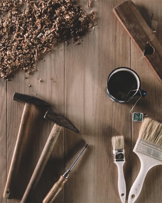kladivo s čopiči za barvanje hiše popravlja skodelico čaja