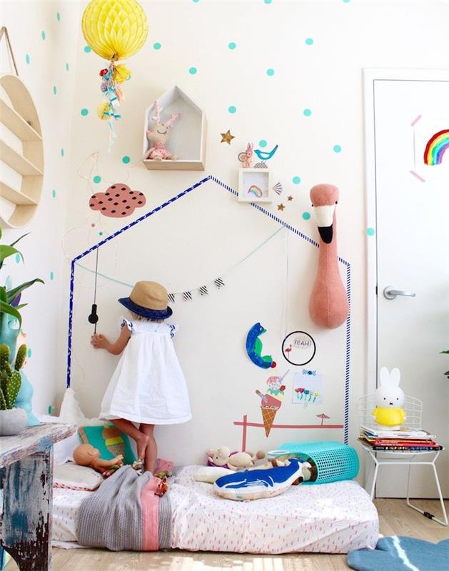 siena, papuošta namų motyvu skalbinių juosta ir kitomis mažomis dekoracijomis, čiužinys ant grindų, maža mergaitė