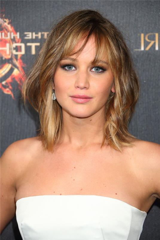 saç boyama, Jennifer Lawrence, koyu renkli kökleri ve altın sarısı uçları olan orta uzunlukta saç kesimi, büstiyerli beyaz elbise