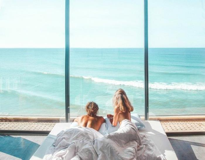 Jauna pora nuotraukoje įsimylėjusi graži pora pajūrio paplūdimio viešbutyje su vaizdu