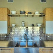 Metalinė mozaika puikiai tinka dekoruoti darbo prijuostę virtuvėje