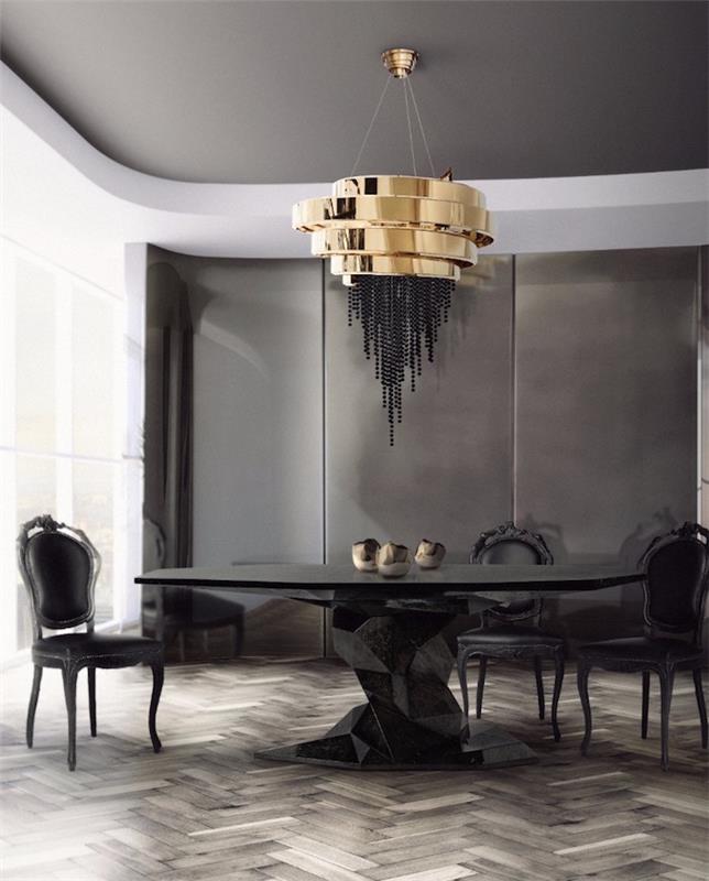 Luksuzna jedilnica v sodobnem umetniškem slogu z oblikovalsko črno mizo in zlatim lestencem v ogleno sivi dekoraciji