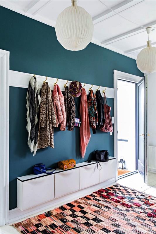 dekoracija hodnika v beli in račji modri barvi, hodnik z omarico za čevlje ikea, kljukami na steni in večbarvno grafično preprogo