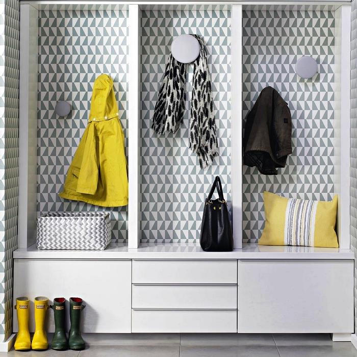 bela garderoba po meri z grafičnimi tapetami in okroglimi sivimi kljukami, sodobna vhodna dekoracija v sivi in ​​rumeni barvi