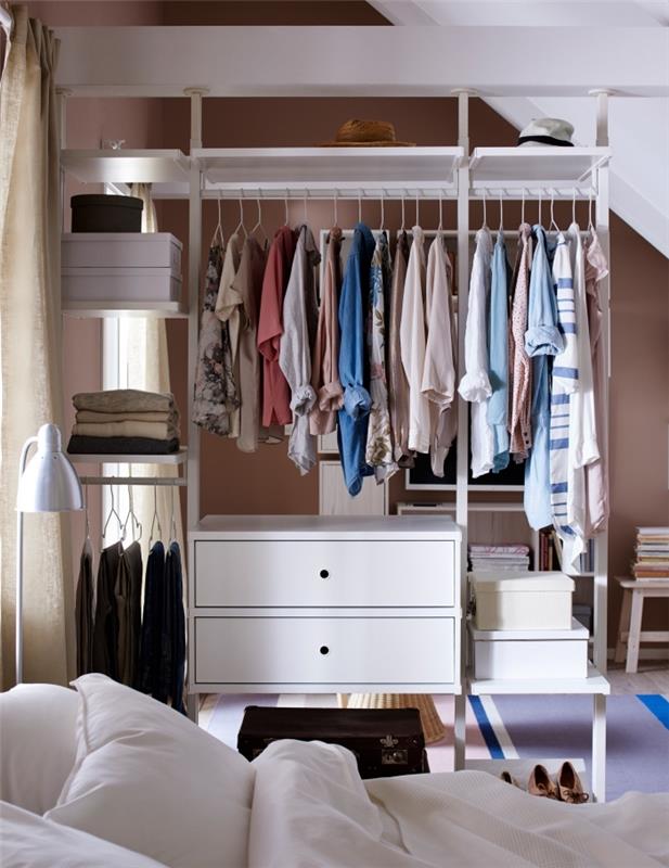 Yatak odasını iki ayrı alana ayıran yatağın yanında açık bir gardırop, ikea giysi saklama sistemi