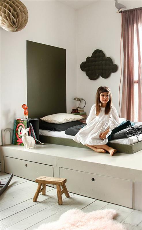 spalnica montessori, pohištvo montessori, postelja montessori na leseni ploščadi, obarvana v zeleni barvi reseda, okrasna plošča v obliki oblaka v ogljeno sivi barvi na steni