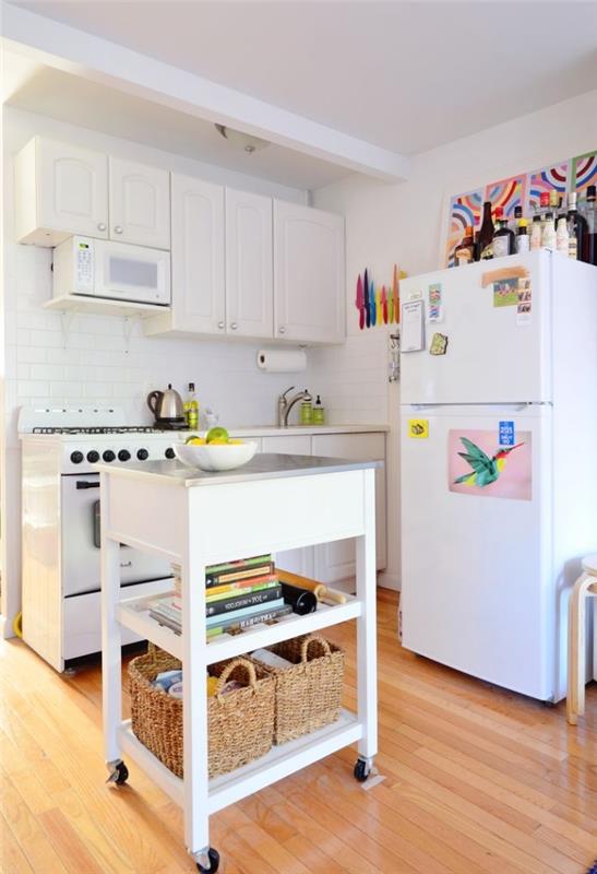 maža balta virtuvė su mobilia centrine sala ant ratukų su dviem laikymo lentynomis, išradingi sprendimai optimizuoti ir įrengti nedidelę virtuvę