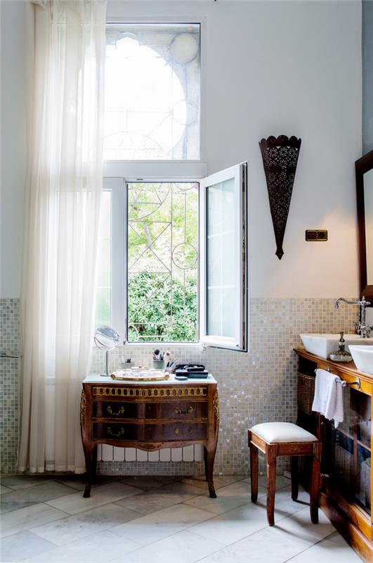 stara kopalnica v maroškem slogu, opremljena s starim bifejem, preoblikovanim v omarico za umivalnik in starinsko komodo, prenovljeno kot toaletno mizo
