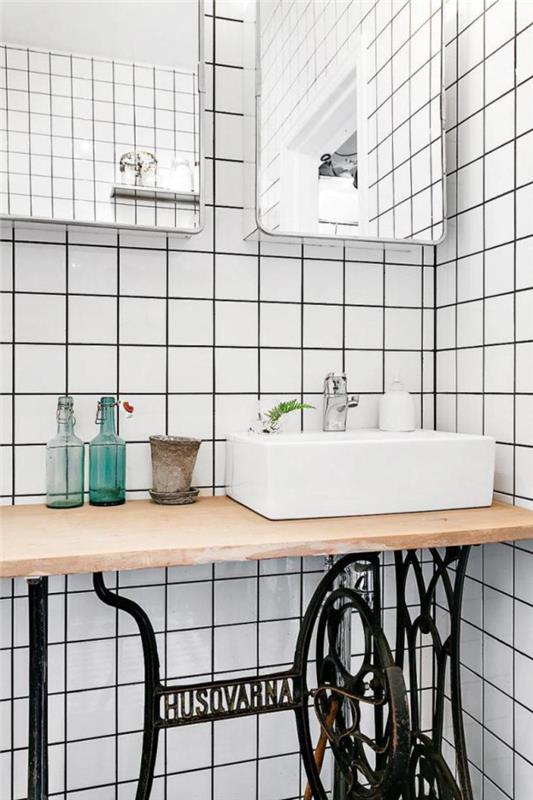 obnovljena omara za umivalnik in trendovske bele ploščice s črnimi spoji za elegantno in starinsko dekoracijo kopalnice