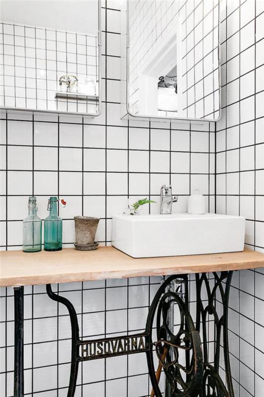 obnovljena omara za umivalnik in trendovske bele ploščice s črnimi spoji za elegantno in starinsko dekoracijo kopalnice