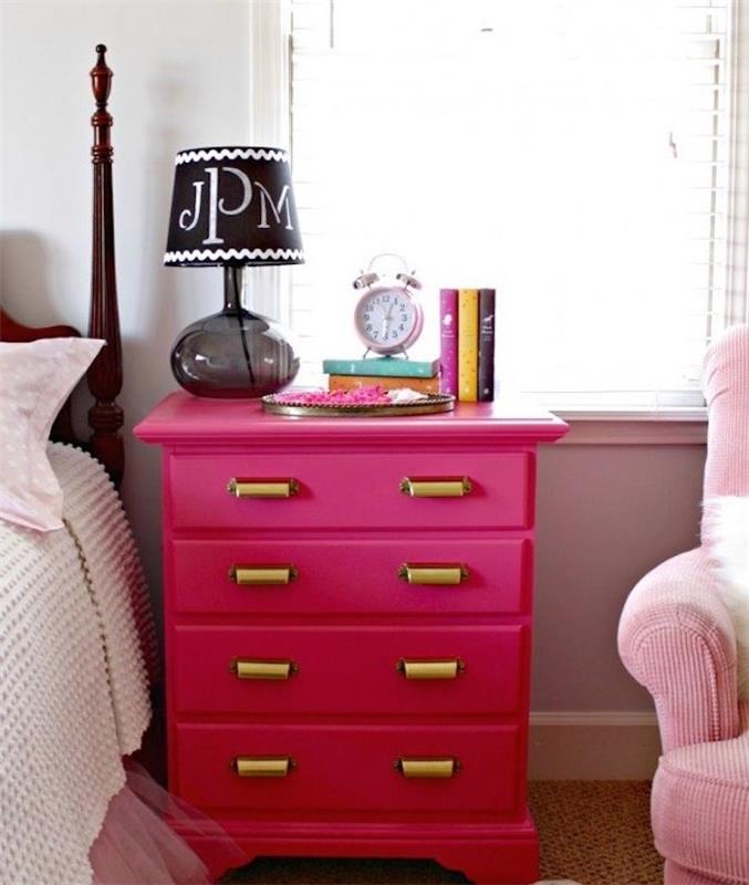 primer pohištva, prebarvano v roza barvo z zlatimi ročaji omare, bleščečo nočno omarico, knjige, budilko, črno nočno svetilko, rožnato in belo posteljnino